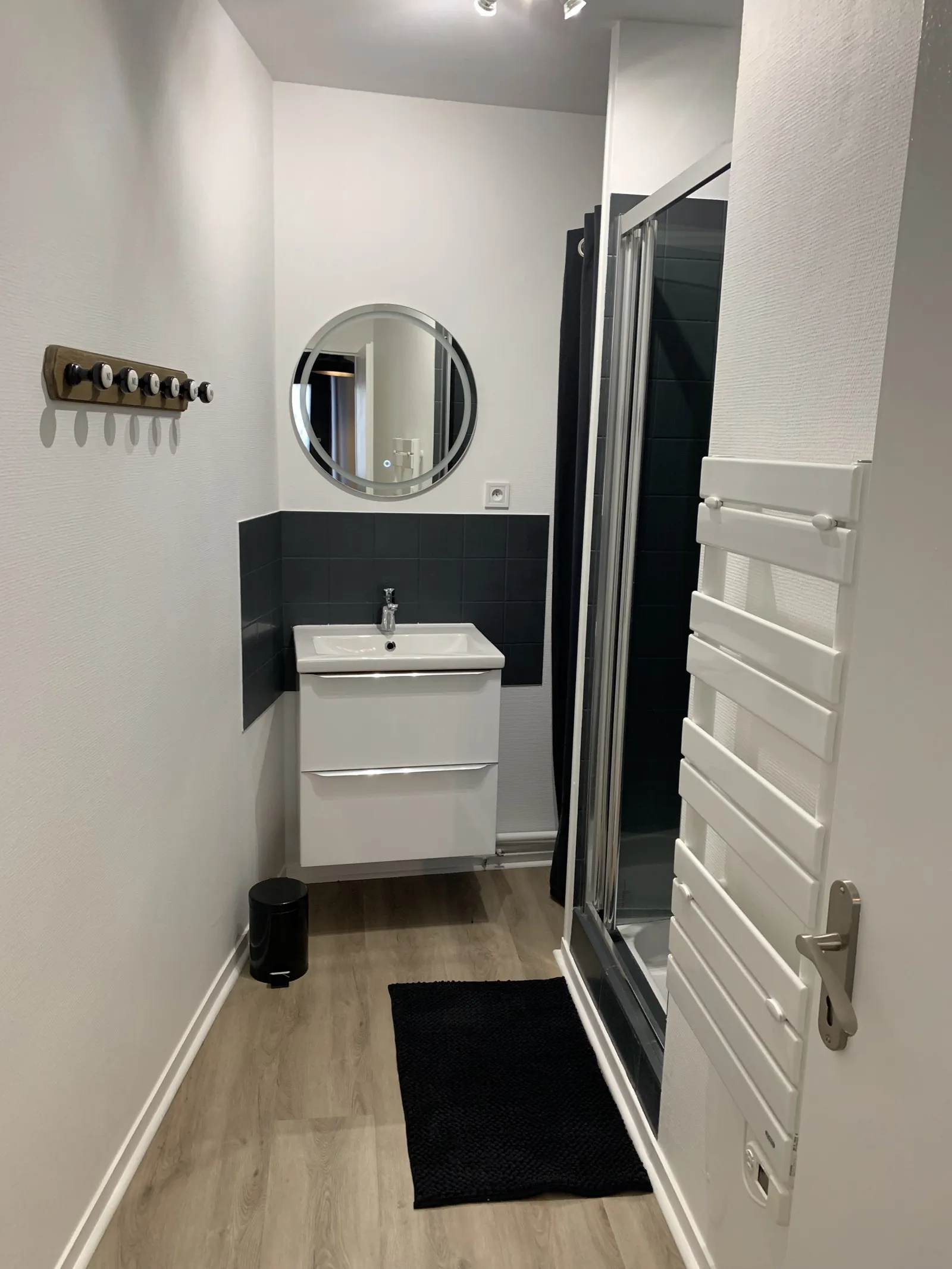 Salle d'eau avec douche, meuble vasque et sèche-serviettes