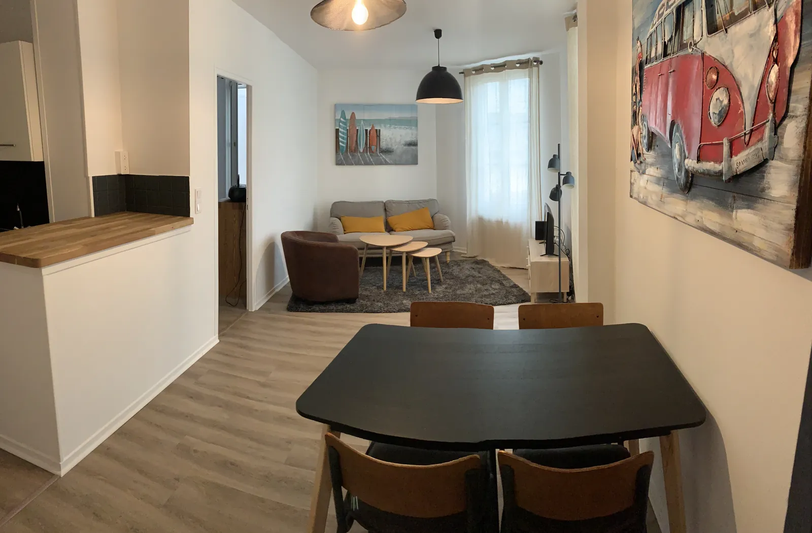 Le séjour de l'appartement CLEMOTI, avec table à manger, coin salon et cuisine ouverte